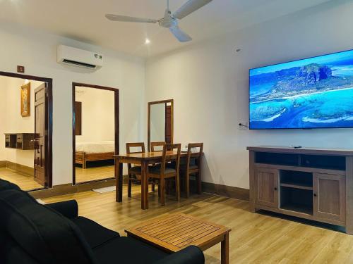 a living room with a table and a tv on the wall at Myhoa Lagoon - Kiting Town in Phan Rang