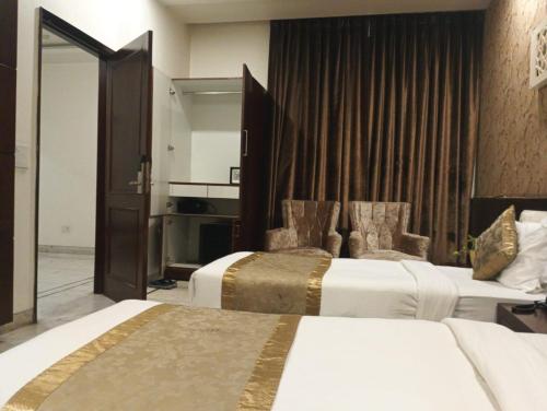 a hotel room with two beds and a mirror at Monarch Residency Gurgaon in Gurgaon