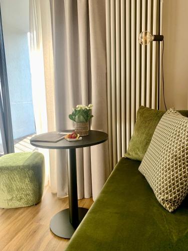 a table with a plant on it next to a couch at Alchimia WellResort in Comano Terme