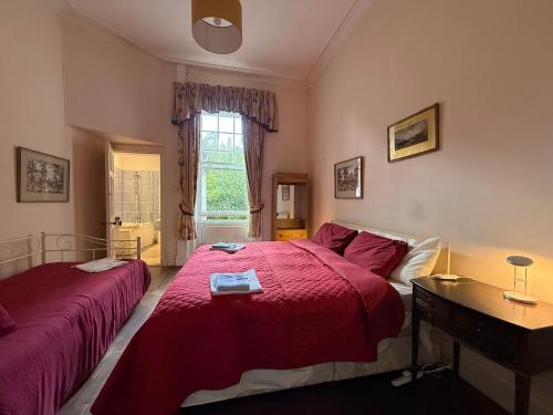a bedroom with two beds and a desk and a window at Shannon River House & Gardens in Limerick
