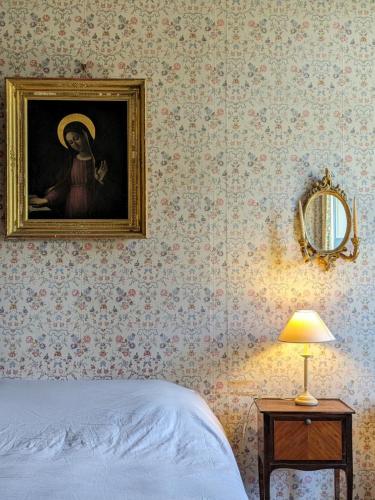 a bedroom with a painting of a woman on the wall at Château de la Garlais - 29 couchages in Derval