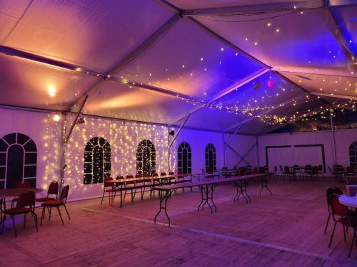 a white tent with tables and chairs and lights at Château de la Garlais - 29 couchages in Derval