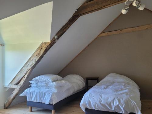 a bedroom with a bed in a attic at Château de la Garlais - 29 couchages in Derval