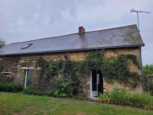 an old stone house with ivy growing on it at Château de la Garlais - 29 couchages in Derval