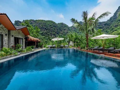 a swimming pool at a resort with mountains in the background at Adumi Retreat Tam Cốc in Vũ Lâm