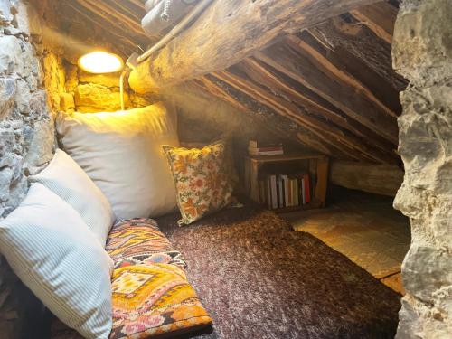 a couch sitting in the corner of a attic at Tiny House El Forn de La Pegatera in Coll de Nargó
