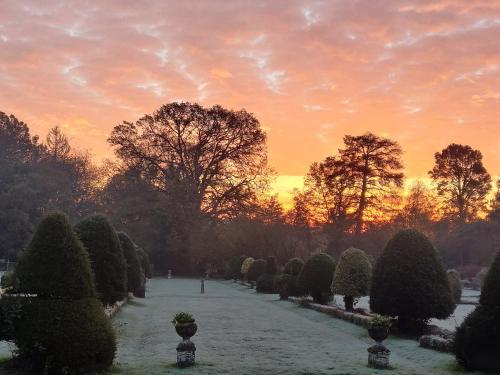 a garden with snow on the ground at sunset at Château de la Garlais - 29 couchages in Derval