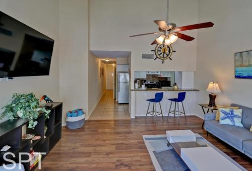 a living room with a couch and a ceiling fan at Gulfpoint 1302 in South Padre Island