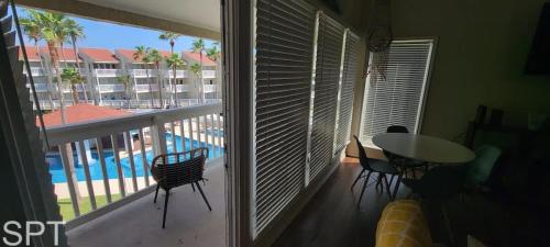 a room with a balcony with a view of a pool at Gulfpoint 1302 in South Padre Island
