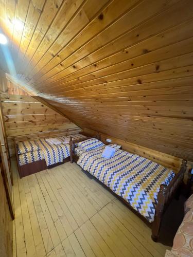 an attic with two beds in a wooden cabin at Breza in Žabljak