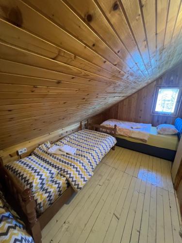 two beds in a room with a wooden ceiling at Breza in Žabljak