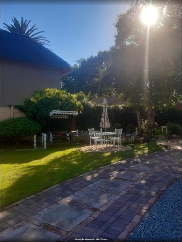a patio with a table and chairs and a light at Die Waenhuis in Parys