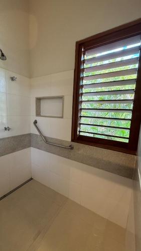 a bathroom with a window and a towel rack at Canto das Pedras House in Mata de Sao Joao