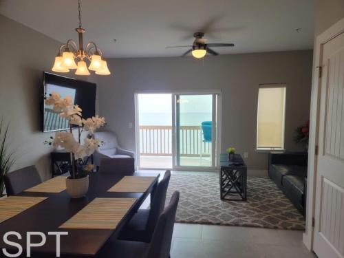 a dining room with a table and a living room with the ocean at Bungalow Tarvana-#1 in Port Isabel