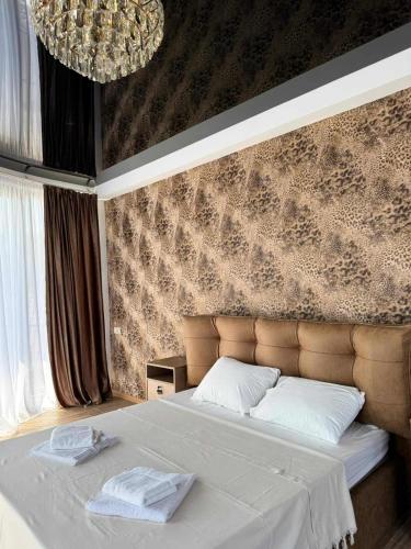 a bedroom with a large bed with white sheets at Shato Mash in Tbilisi City