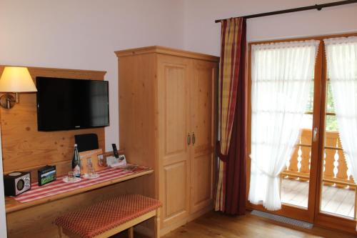 a living room with a tv and a window at Naturparkhotel Schwarzwaldhaus in Bernau im Schwarzwald