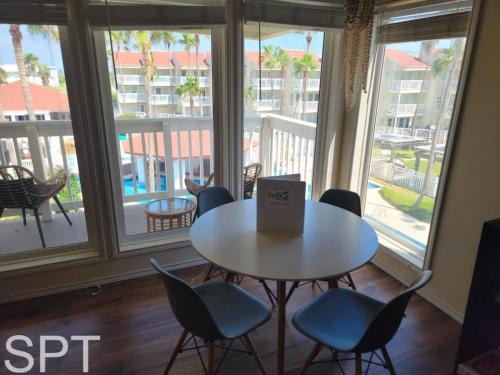 a table and chairs in a room with windows at Gulfpoint 1302 in South Padre Island
