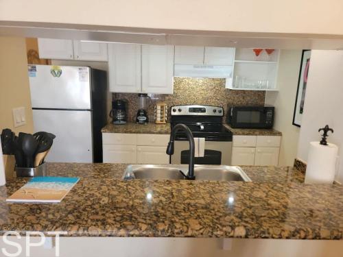 a kitchen with a sink and a refrigerator at Gulfpoint 1302 in South Padre Island