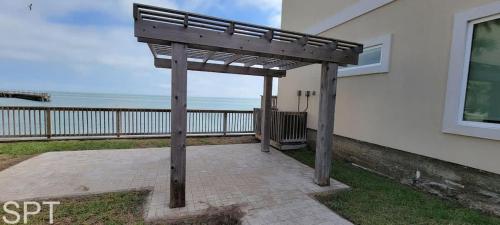 a wooden pergola on the side of a house at Bungalow Tarvana-#1 in Port Isabel