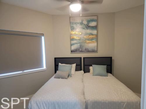 a bedroom with two beds and a painting on the wall at Bungalow Tarvana-#1 in Port Isabel