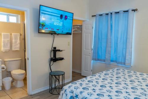 a bedroom with a bed and a flat screen tv at Clean Pool Walk to Beach - Pet Ok - Ground Floor in South Padre Island