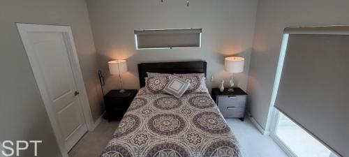 a bedroom with a bed with two night stands and two lamps at Bungalow Tarvana-#1 in Port Isabel