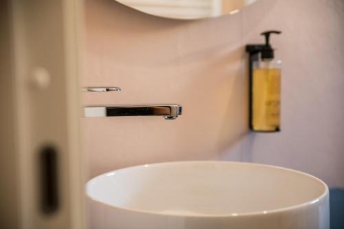 a white sink in a bathroom with a soap dispenser at Show MI Rooms Milano - San Siro Stadio - Ippodromo - Rho Fiera in Milan