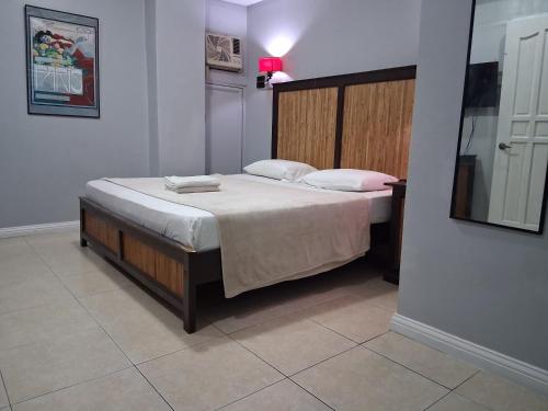 a bedroom with a large bed with white sheets and pillows at Hotel Le Carmen in Cebu City