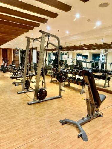 a gym with a row of treadmills and machines at Condo Monarch Parksuites in Sampong