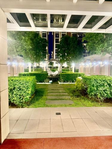 a view of a garden at night with lights at Condo Monarch Parksuites in Sampong