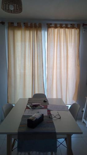 a table in a room with white curtains at Depa pleno centro Santa Fe in Santa Fe
