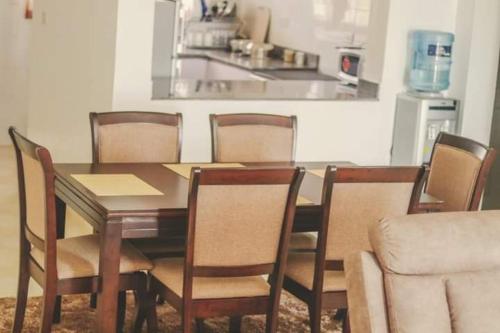 a dining room table with chairs and a kitchen at Indian Ocean Sea View Apartments at Kijani, Malindi in Malindi