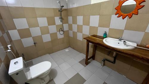 a bathroom with a toilet and a sink at Lodge Jamarek in Kafountine