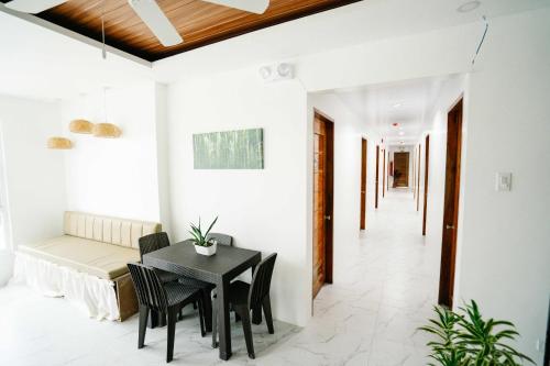 a dining room and living room with a table and chairs at MGM Tourist Inn in Tagbilaran City
