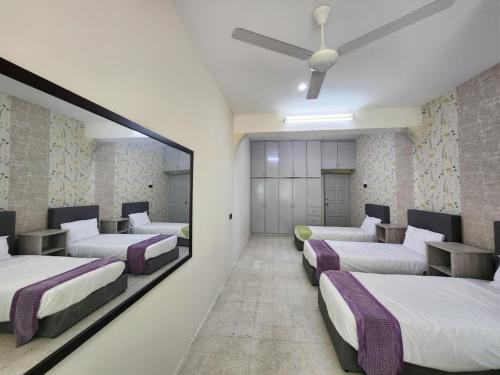 a row of beds in a room with a mirror at Ipoh Tambun pool villa 5br20pax bbq karaoke mahjong in Ipoh