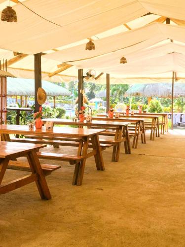 a row of picnic tables under a tent at Libhu Hill Resort and Sports Complex in Maasin