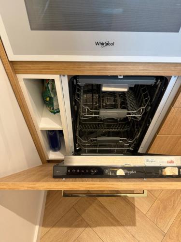 un forno a microonde con la porta aperta in un armadio di Sunny apartment- Parko rezidencija SELF CHECK-IN a Panevėžys