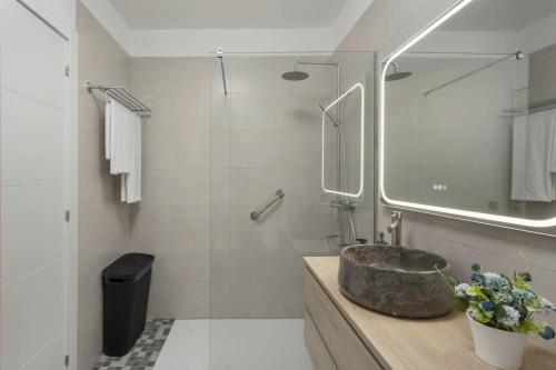 a bathroom with a stone sink and a mirror at Apartamento Refugio del Mar in Candelaria