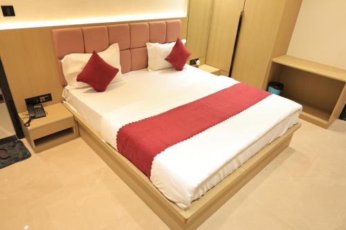 een slaapkamer met een groot bed met rode en witte kussens bij The Basil Hotel in Udaipur