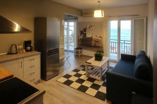 a kitchen and living room with a couch and a table at Sappho Plomari in Plomarion