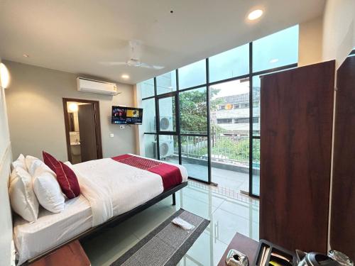 une chambre avec un lit et une grande fenêtre dans l'établissement SwagStay Hotel Riviera Grand, Nagpur, à Nagpur