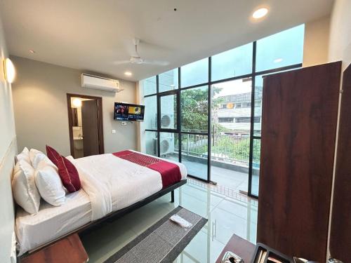 a bedroom with a bed and a large window at SwagStay Hotel Riviera Grand, Nagpur in Nagpur