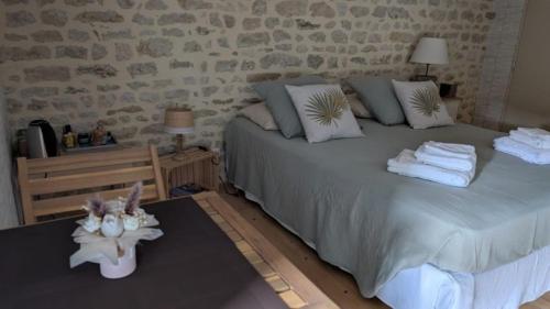 a bedroom with two beds and a stone wall at Les Volets Bleus in Bernay