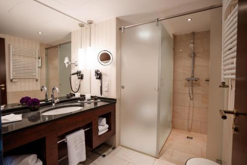 a bathroom with a sink and a shower at Hotel Vier Jahreszeiten Starnberg in Starnberg