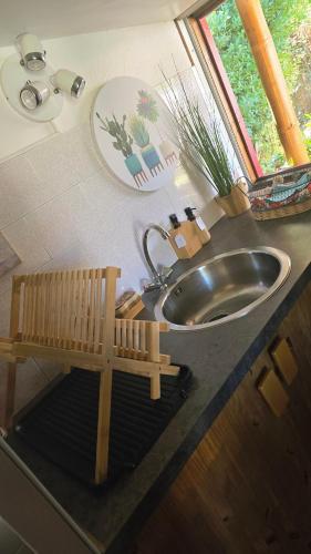 a bathroom sink with a wooden bench next to it at Le Chalet des Dany in Saint-Mamert-du-Gard