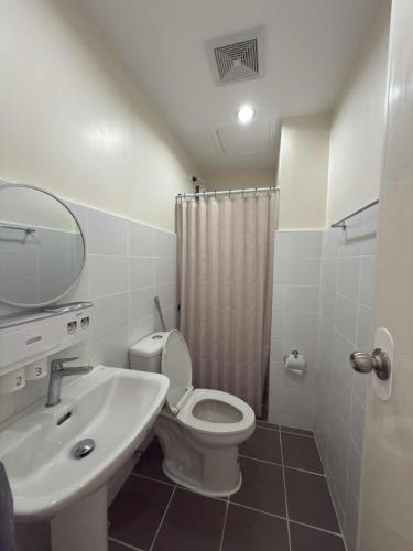 a bathroom with a sink and a toilet and a shower at Condo with Balcony near Mactan Newtown in Mactan