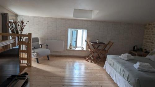 a bedroom with a bed and a table and a window at Les Volets Bleus in Bernay