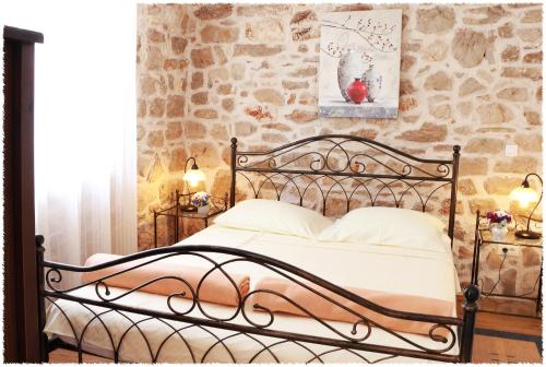 a bed in a room with a stone wall at Apartment Dane in Primošten
