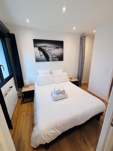 a bedroom with a bed with two towels on it at L'Apparté Confort in Thonon-les-Bains