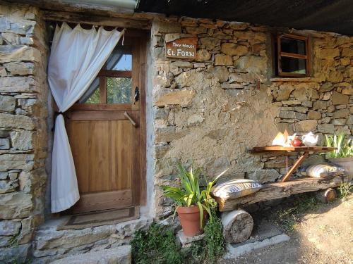 a stone building with a wooden door and a window at Tiny House El Forn de La Pegatera in Coll de Nargó